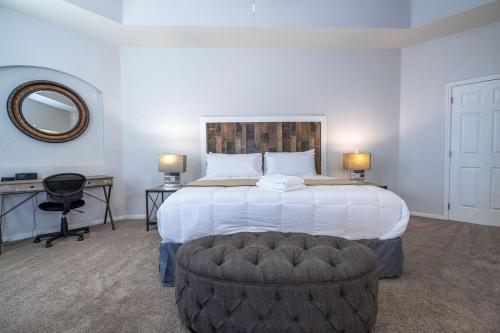 a bedroom with a large white bed with a circular stool at Cozy 4Bd Home Pool & Hot Tub at Trafalgar Resort in Kissimmee