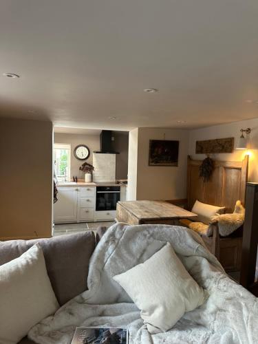 ein Wohnzimmer mit Couch und Küche in der Unterkunft Cedar Cottage newly renovated cottage in Matlock