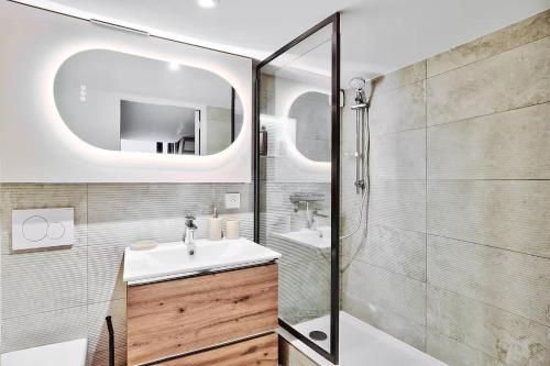 une salle de bain avec un lavabo et une douche avec un miroir dans l'établissement Le Nid Suspendu, à Lyon