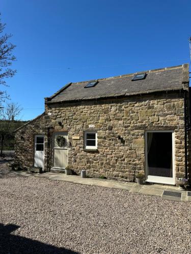a stone building with two windows and a garage at Cedar Cottage newly renovated cottage in Matlock