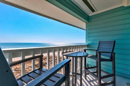 two chairs and a table on a balcony with the beach at Boardwalk 301 by Carolina Beach Realty in Carolina Beach