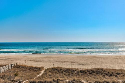 an empty beach with the ocean in the background at Boardwalk 301 by Carolina Beach Realty in Carolina Beach