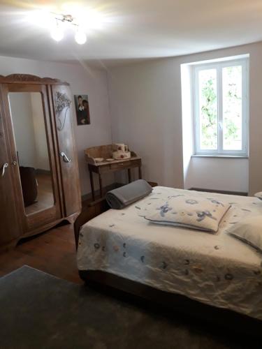une chambre avec un lit, une commode et une fenêtre dans l'établissement La ferme au marronnier, à Valence-dʼAlbigeois