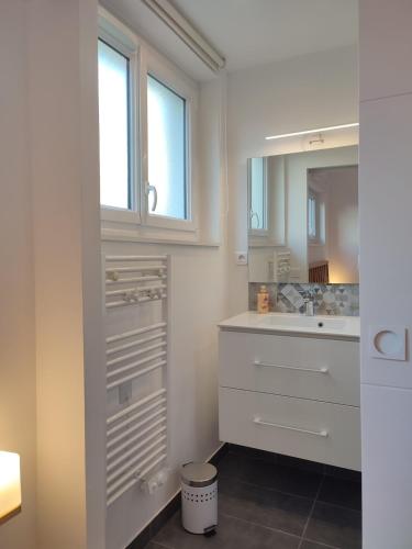 La salle de bains est pourvue de placards blancs et d'un lavabo. dans l'établissement Terra Marine - T2 - Centre ville, à Concarneau