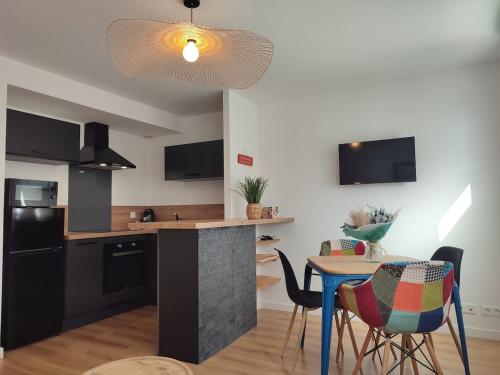 une cuisine et une salle à manger avec une table et des chaises dans l'établissement Terra Marine - T2 - Centre ville, à Concarneau