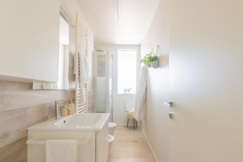 a white bathroom with a sink and a toilet at Vibra Tahiti Prestige in Lido di Jesolo