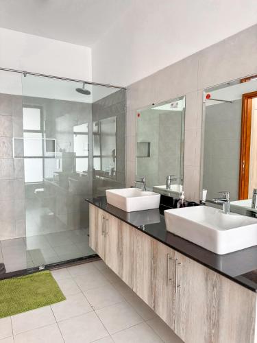 a bathroom with two sinks and two mirrors at Marina Beachfront at JUMEIRAH PALM RESORT-NYALI in Mombasa