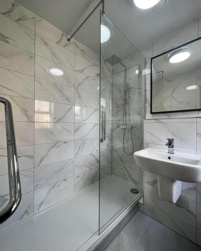 a white bathroom with a shower and a sink at Gomersal Park Hotel & Bazaar Spa in Cleckheaton