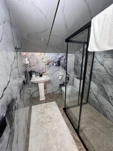 a marble bathroom with a sink and a toilet at FlowerHouse in Karakol