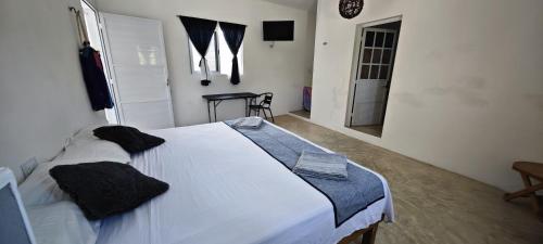a bedroom with a large white bed in a room at Casa Universo Holbox in Holbox Island