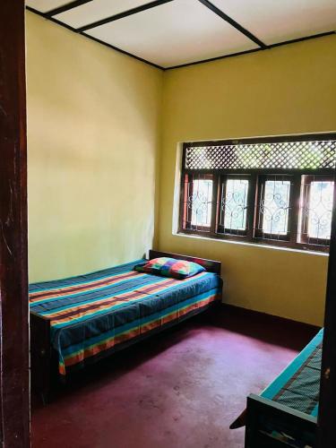 a bedroom with a bed in a room with windows at Home Stay Badulla in Badulla