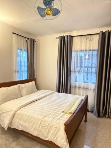 a bedroom with a bed and a ceiling fan at Logic stays 3 bedroom Arusha, Njiro in Arusha