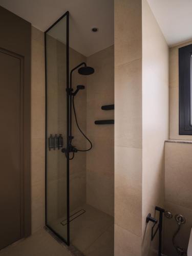 a shower with a glass door in a bathroom at Brassbell Zamalek Diplomatic Zone Near Marriott in Cairo