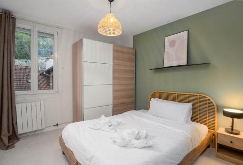 une chambre avec un lit avec des serviettes blanches dessus dans l'établissement Appartement tout confort entre Versailles & Paris - Calme et 2 chambres équipées, à Le Port-Marly