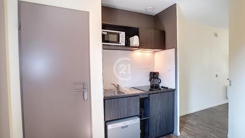 a small kitchen with a sink and a microwave at Appartement résidence de vacances les Hameaux de Camargue in Arles