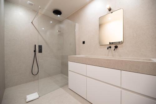 une salle de bain avec une douche, un lavabo et un miroir dans l'établissement Bastille - Crémieux Residence, à Paris