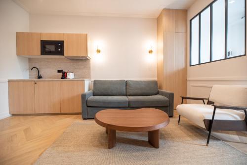 un salon avec un canapé et une table dans l'établissement Bastille - Crémieux Residence, à Paris