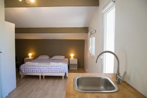 - une cuisine avec évier et un lit dans une chambre dans l'établissement Maison 3 chambres à 200 m de la plage, à Six-Fours-les-Plages