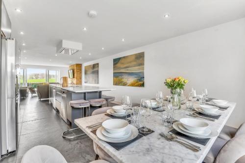 a dining room with a table and a kitchen at The Duchess - North East Escapes in Bamburgh