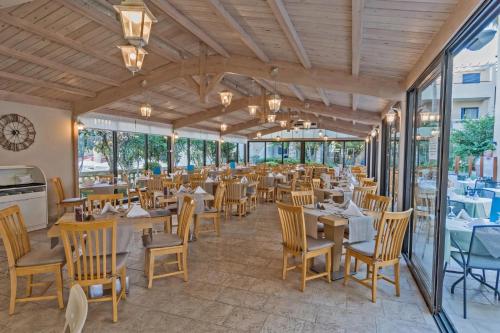 a restaurant with tables and chairs and windows at Pearl Beach in Rethymno Town