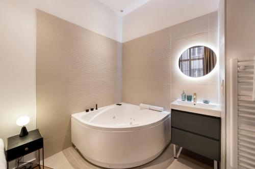 une salle de bain blanche avec une baignoire et un lavabo dans l'établissement Cosy opéra, à Lyon