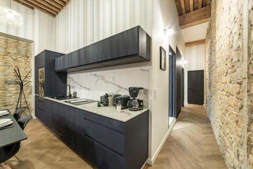 une cuisine avec des armoires noires et un comptoir dans l'établissement Opéra Muse, à Lyon