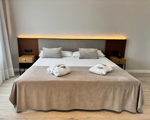 two towels sitting on top of a large bed at ARVA Santiago León in León