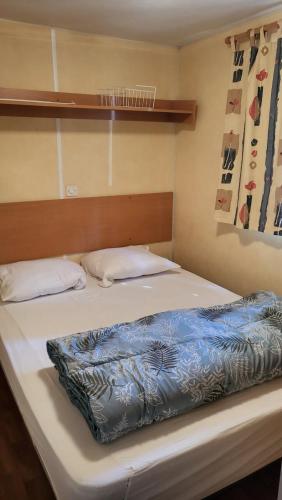 un lit dans une chambre avec deux oreillers dessus dans l'établissement Mobil home 3 chambres, à Saint-Georges-de-Didonne