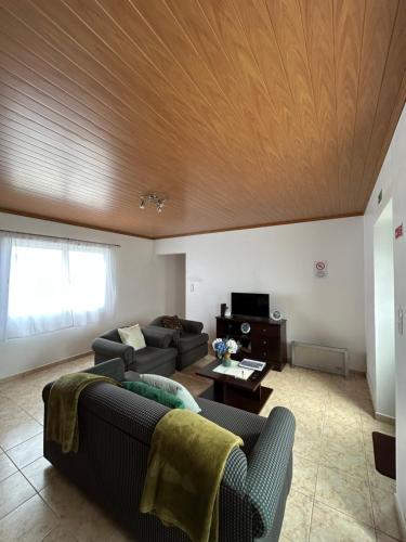 a living room with a couch and a wooden ceiling at Nordesteza House in Nordestinho