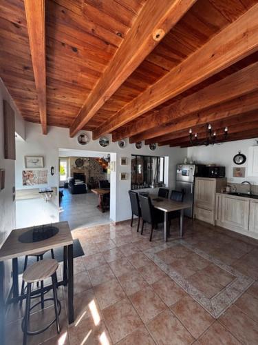Il comprend une cuisine avec des plafonds en bois, une table et des chaises. dans l'établissement Grand gîte 8pers, proche mer, jardin et barbecue, à La Celle-sous-Gouzon
