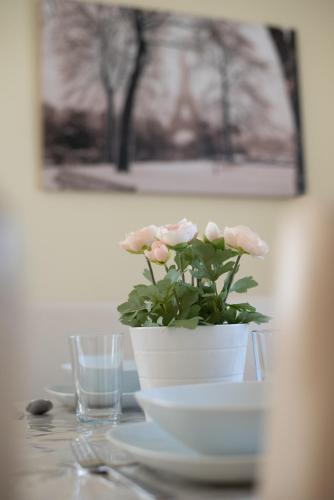 a white vase with pink flowers on a table at Sunny Beach in Zánka