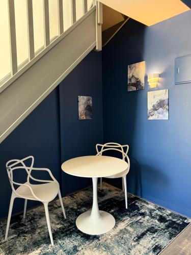 a table and two chairs in a room with blue walls at Hôtel De Paris in Sète
