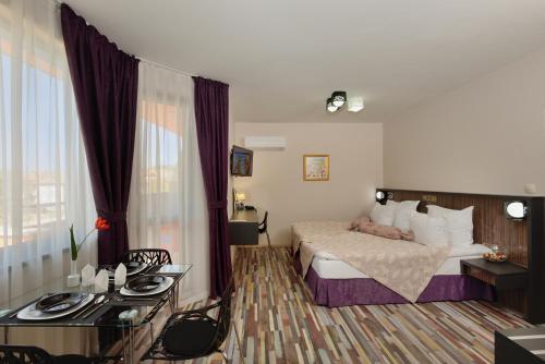 a hotel room with a bed and a desk and a room at Apart Hotel Hello Hissar in Hisarya