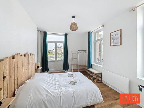 une chambre avec un lit blanc et une fenêtre dans l'établissement Le Petit Edmond, à Wimereux