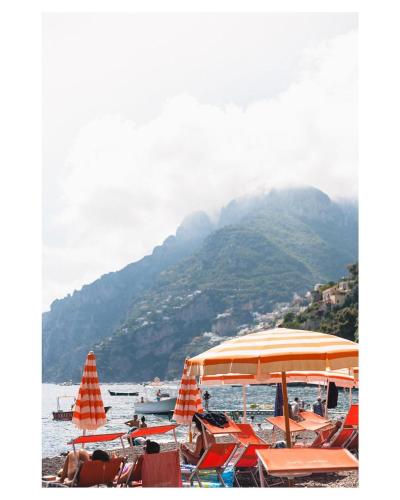 a group of boats in the water with a mountain at La Maliosa Positano in Positano