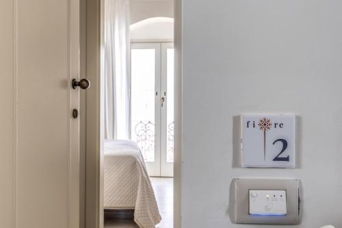 a white door with a clock and a lightswitch at B&B Fiore in Gallipoli
