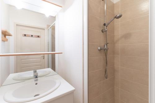 une salle de bain avec un lavabo et une douche dans l'établissement La Joue du Loup, appartement pour 4, balcon, à Saint-Étienne-en-Dévoluy