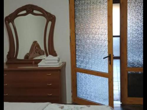 a bedroom with a dresser and a mirror next to a door at RETRO house in Korçë