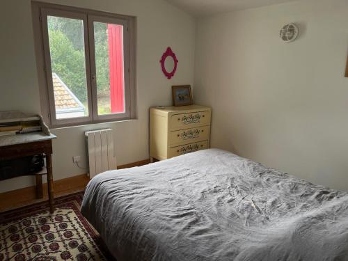 une chambre avec un lit, une commode et une fenêtre dans l'établissement Grande maison entre mer et fôret, à La Celle-sous-Gouzon