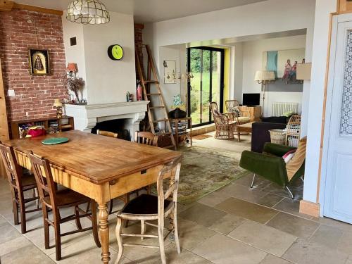 - un salon avec une table en bois et une cheminée dans l'établissement Grande maison entre mer et fôret, à La Celle-sous-Gouzon
