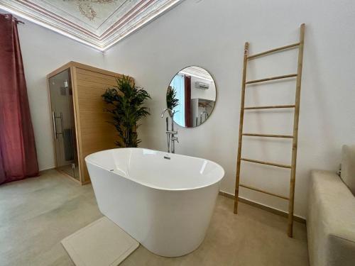 a bathroom with a white tub and a mirror at Massimo Rooms and suite in Palermo