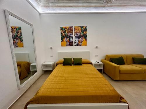 a bedroom with a yellow bed and a couch at Massimo Rooms and suite in Palermo