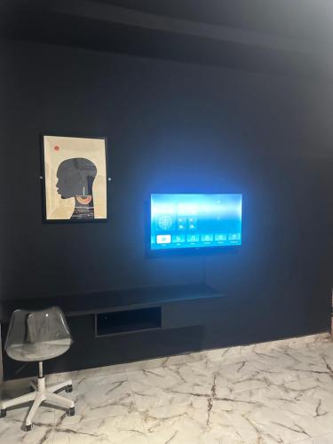 a blue wall with a desk and a chair in a room at Aqua black studio room in Lagos