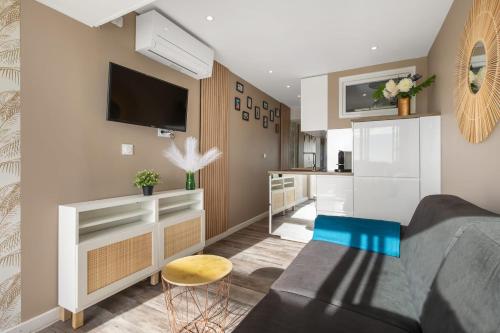 un salon avec un canapé et une télévision dans l'établissement La Boho plage Port Nature, au Cap d'Agde