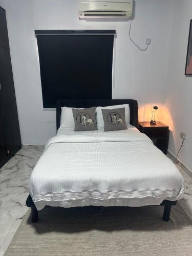 a bed with two pillows on it in a bedroom at Aqua black studio room in Lagos