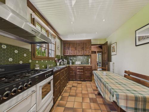 Il comprend une cuisine équipée d'une cuisinière et d'un canapé. dans l'établissement Maison pour 10 avec grand jardin à 250m de la mer, à Louannec