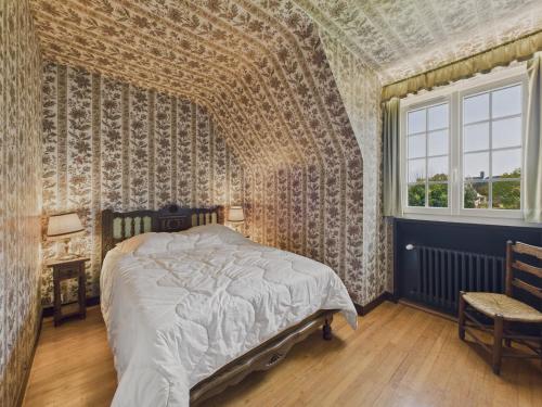 a bedroom with a bed and a window at Maison pour 10 avec grand jardin à 250m de la mer in Louannec