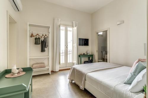 a white bedroom with a bed and a window at B&B Fiore in Gallipoli