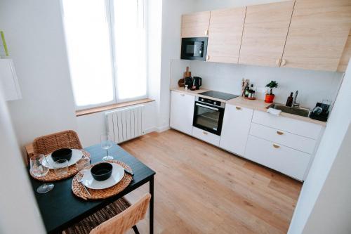 - une petite cuisine avec une table et 2 assiettes dans l'établissement T1bis cocooning au calme, à Brest