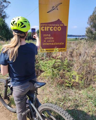 a woman standing next to a bike next to a sign at Eco House San Michele in San Michele